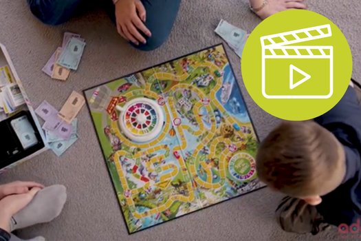 Family playing board game with Adopt Coast to Coast video icon on image