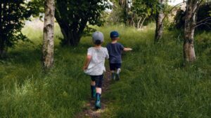 Two young boys running through a field