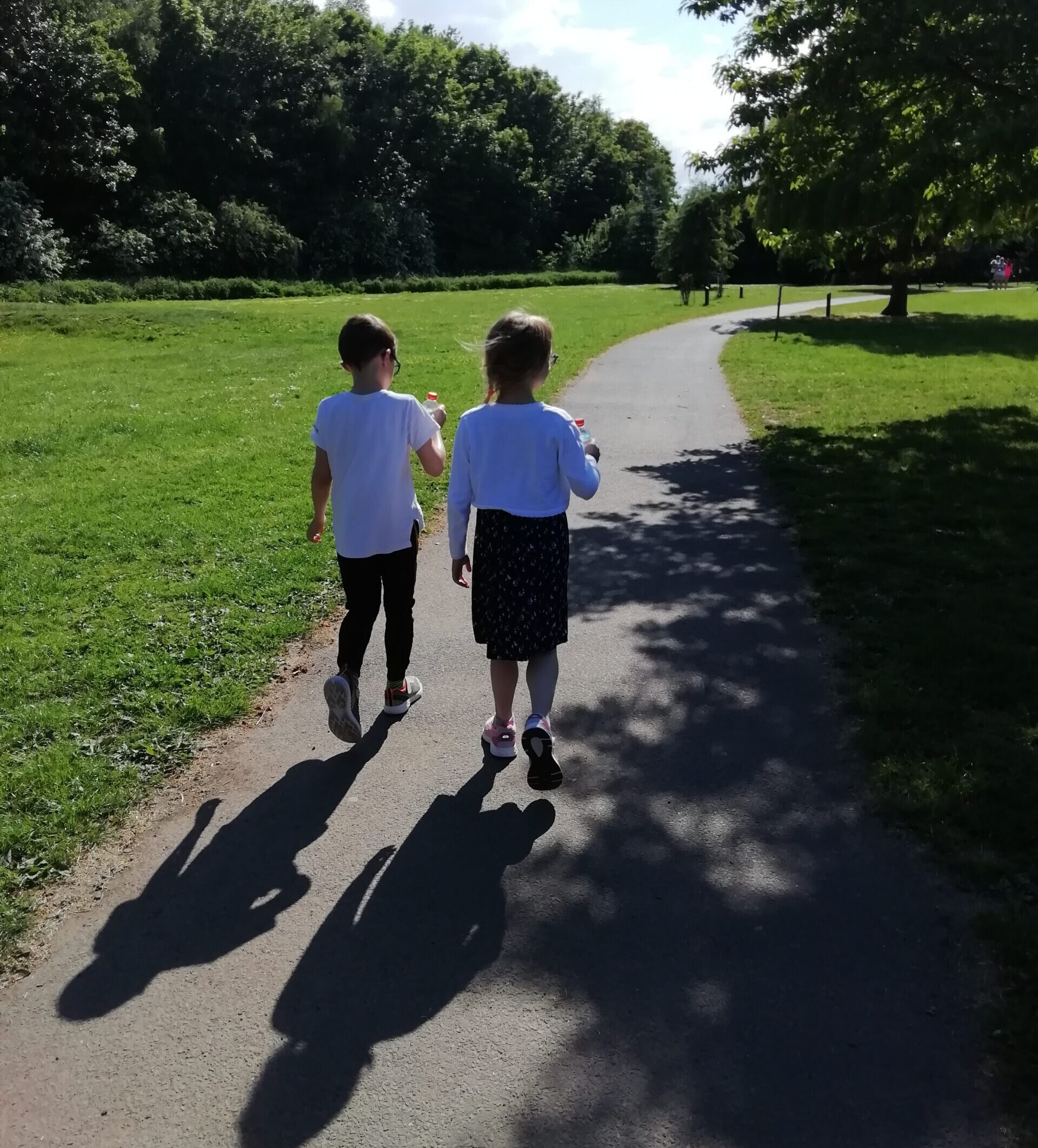 Young boy and girl in school uniforms walking away