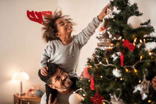 Dad and daughter decorating the Christmas tree