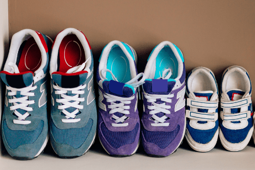 Three pairs of trainers in a row in different sizes
