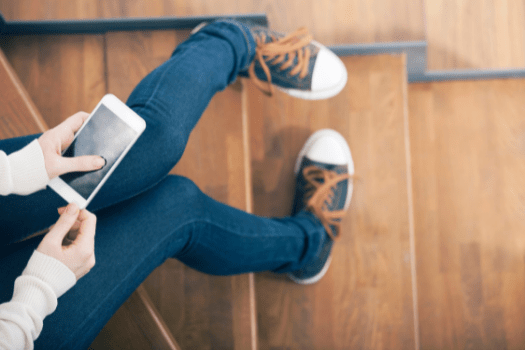 Teenage sitting on stairs on phone