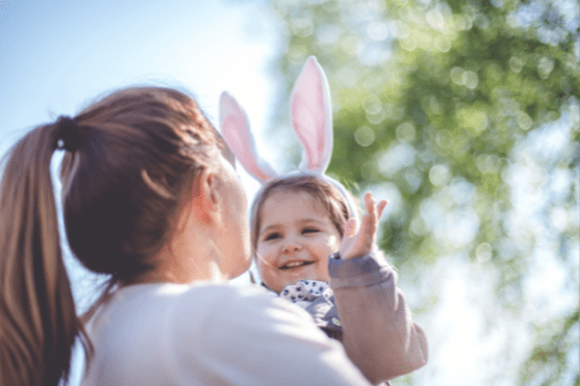 Woman holding little girl with bunny ears