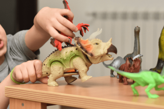 Little boy playing with dinosaur toys