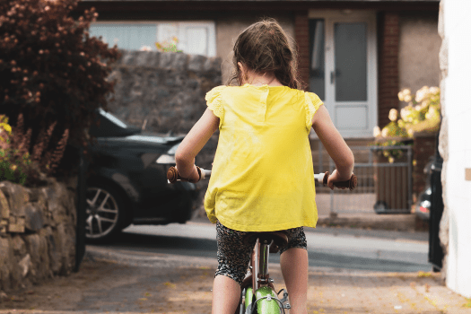 Little girl riding a pink bike