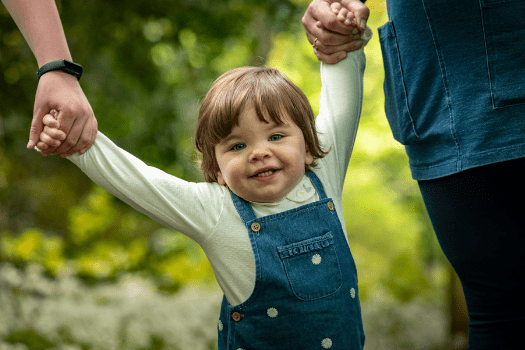 Little girl holding hands with her mammy and brother