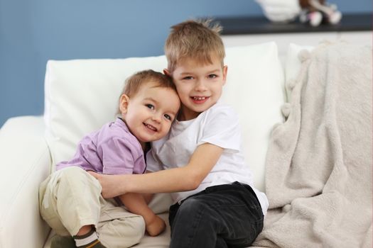 Brothers hugging on a sofa