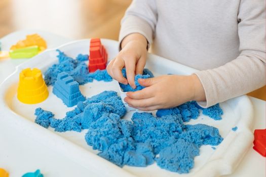 Toddler playing with kinetic sand