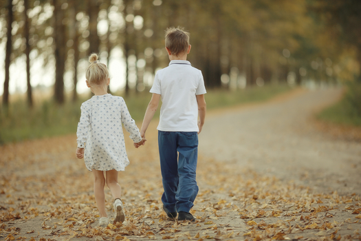 Little boy and girl walking away